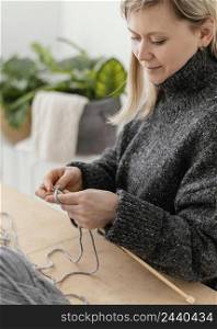 close up woman knitting home
