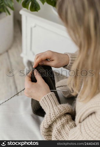 close up woman knitting with metallic needles