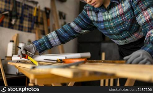 close up woman measuring wood plank