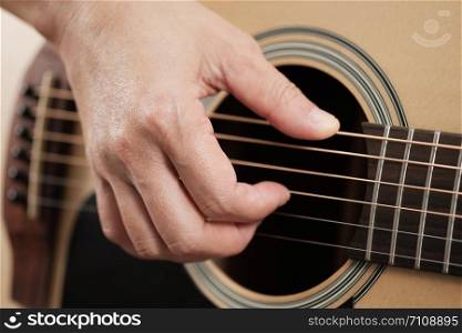 Close up woman&rsquo;s hands playing acoustic guitar.