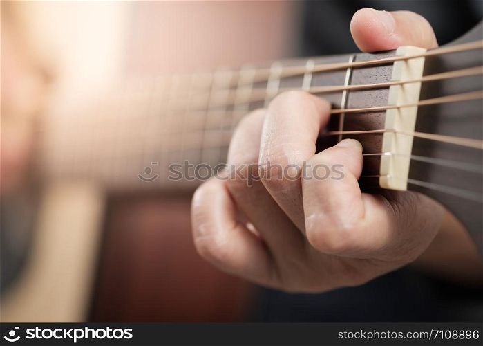 Close up woman&rsquo;s hands playing acoustic guitar.
