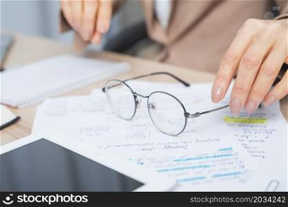 close up woman s hand holding eyeglasses document