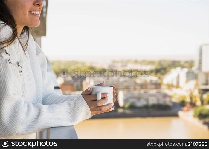 close up woman standing balcony with cup coffee