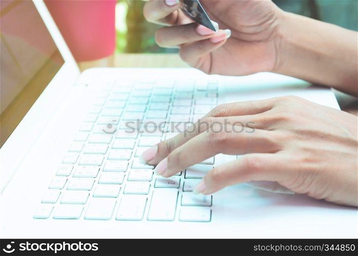 Close up woman using laptop and credit card. Online shopping or E-commerce concept.