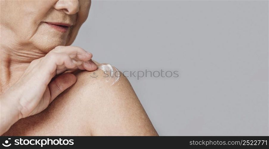 close up woman using shoulder cream