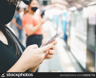 close-up woman wear protective mask and using smartphone in public transport.