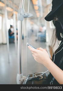 close-up woman wear protective mask and using smartphone in public transport.