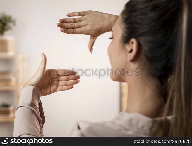 close up woman with camera hands gesture