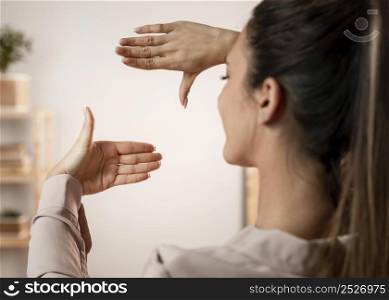 close up woman with camera hands gesture