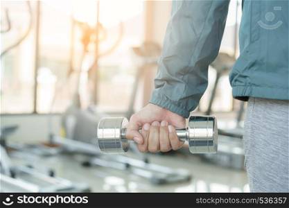 Close up woman with dumbbells in hand. Asian woman in sportswear exercising at fitness on the morning