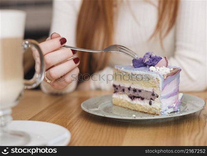 close up woman with fork delicious blueberry cake slice plate wooden table