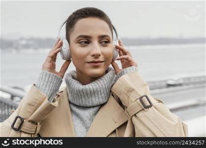 close up woman with headphones outside