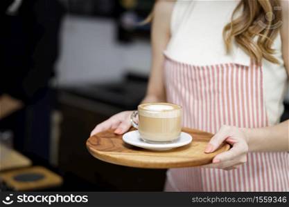 Close up women holding cup of coffee mug latte at coffee shop