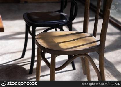 close up wooden chair seat with shadow and light on grunge cement ground