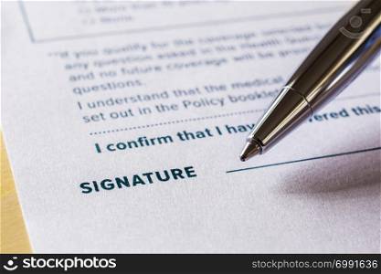 Close up word signature with pen on legal contract form. Policy document, registration, employment and business startup concept.