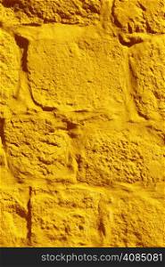 Close up yellow paint uneven old concrete wall background or texture