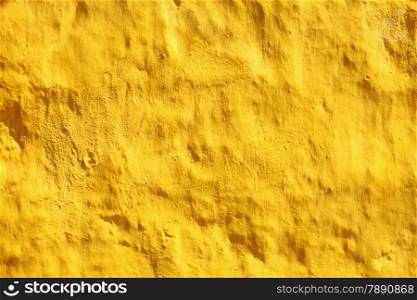 Close up yellow paint uneven old concrete wall background or texture