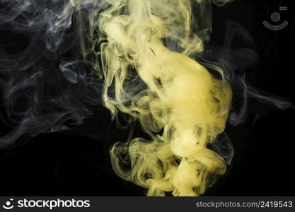 close up yellow smoke against black background