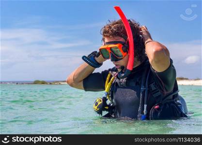 Close up young caucasian diver standing in sea