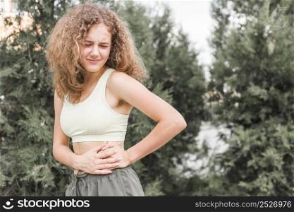close up young female athlete having pain her waist