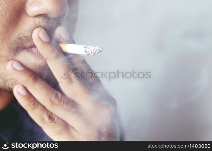 Close up young man smoking a cigarette.