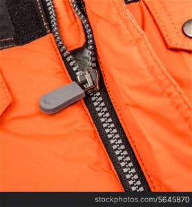Close up zipper on an orange background