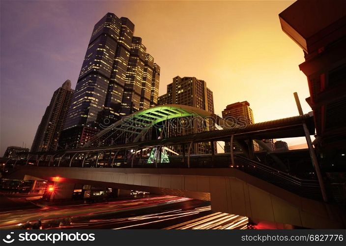 Close view Cityscape Modern building at sunset and cloudy sky.Traffic in the business district The Skytrain station Chong Nonsi,Bangkok,Thailand
