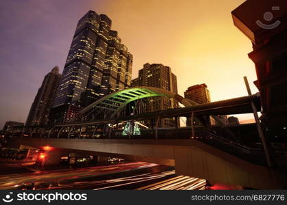 Close view Cityscape Modern building at sunset and cloudy sky.Traffic in the business district The Skytrain station Chong Nonsi,Bangkok,Thailand