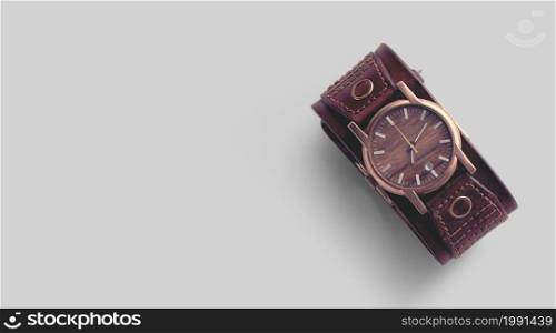 Close view of brown leather man`s wrist watch on grey background.