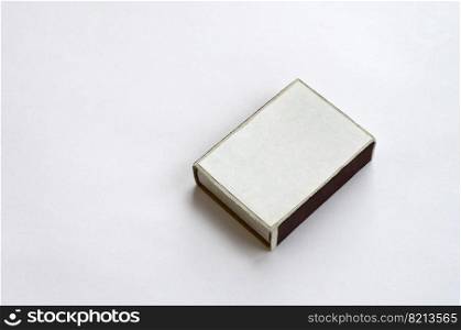 Closed cardboard matchbox on a white background. Flat lay minimal. Top view with text space. Closed cardboard matchbox on white background close up