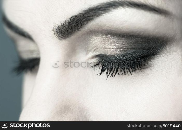 Closed eyes sensual smoky makeup detailed closeup, toned cross processed image
