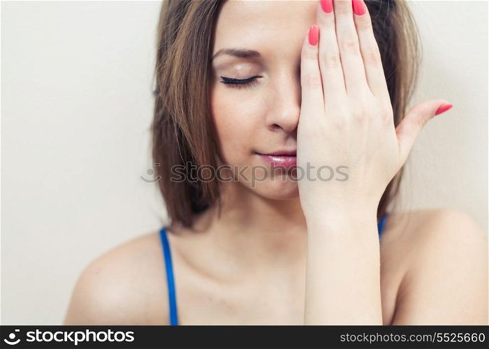 Closed eyes women hiding her eye by hand head and shoulders image
