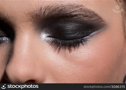 Closed female eye with modern fashionable makeup. Close-up. Eye of a girl with makeup