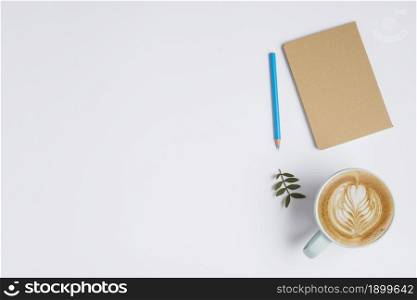closed notebook colored pencil leaves cup coffee with latte art white background. Resolution and high quality beautiful photo. closed notebook colored pencil leaves cup coffee with latte art white background. High quality beautiful photo concept