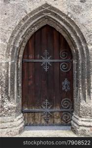 Closed old oak door at ancient stone cathedral