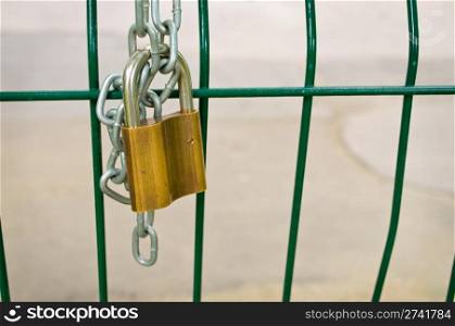 Closed padlock and chain on a fence