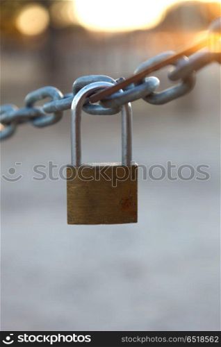 Closed padlock hanging from a chain. Closed padlock hanging from a thick chain