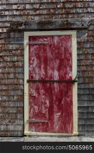 Closed red door on a Fishing shed at harbor, Peggy's Cove, Nova Scotia, Canada