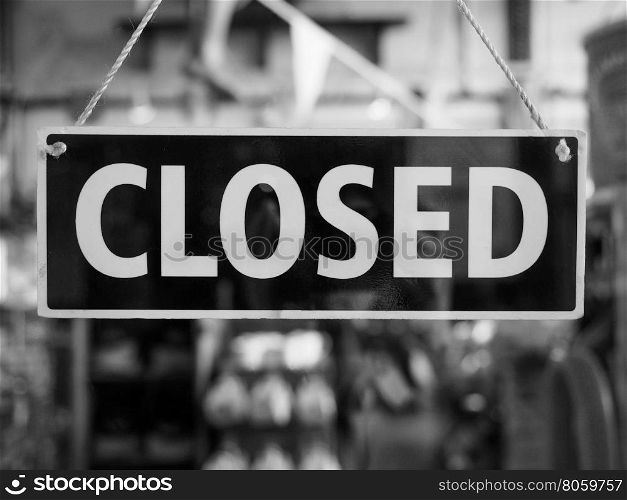 Closed sign on a shop window. Closed sign in a shop showroom with reflections in black and white