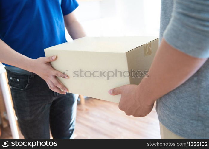 Closed up asian man hand receive shipment from delivery man, order box shipping from online store website to deliver at home. Courier domestic logistic service business to between sender and receiver