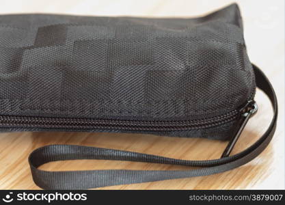 Closed up black bag on wooden table, stock photo