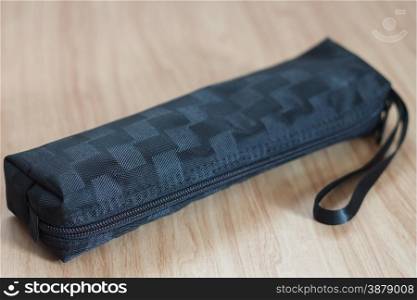 Closed up black bag on wooden table, stock photo