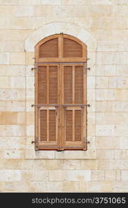 Closed window of the old building covered by wooden blinds