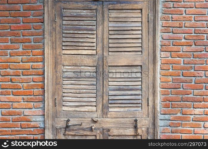Closed wooden door with red bricks wall in old vintage house. Abstract background. Old fashion, retro construction style.