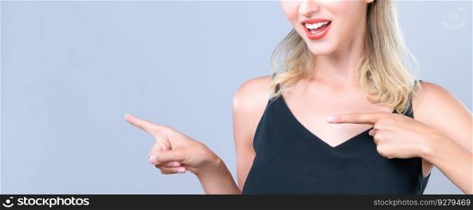 Closeup Alluring beautiful perfect makeup clean skin woman portrait pointing finger side way in copyspace isolated background. Promotion indicated by hand gesture concept for skincare advertisement.. Closeup alluring woman portrait pointing finger side way in isolated background.