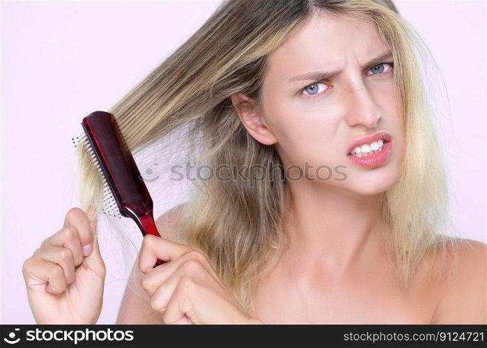 Closeup alluring portrait of beauty cosmetic clean skin woman having brittle dry hair problem. Grimacing frustrated sad facial expression in pink isolated background. Damaged and hair loss concept.. Closeup alluring woman portrait with cosmetic skin having hair loss problem.