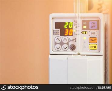 Closeup an infusion pump intravenous iv drip with level indicator displays in hospital room. Copy space wallpaper.