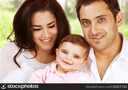 Closeup arabic family portrait spending time outdoors, young parents with little daughter in the park, love and happiness concept