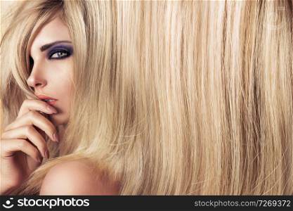 Closeup art portrait of a young, blond model with long straight hair