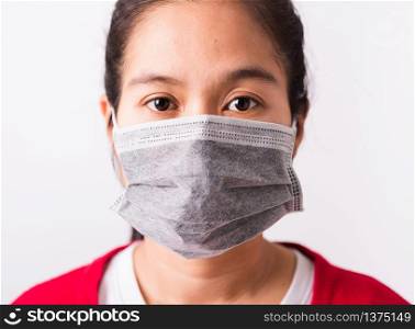 Closeup Asian adult woman wearing red shirt and face mask protective against coronavirus, COVID-19 virus or filter dust pm2.5 and air pollution she looking camera studio shot isolated white background